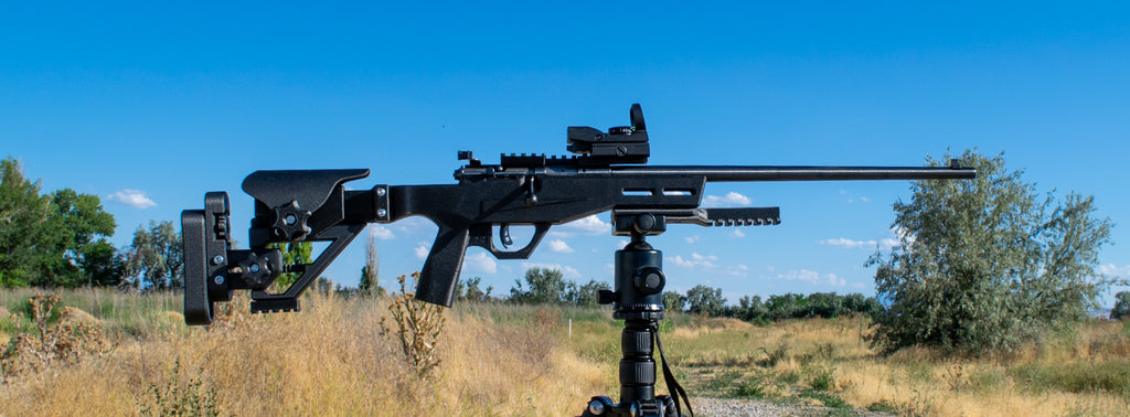 Black rifle on tripod in field