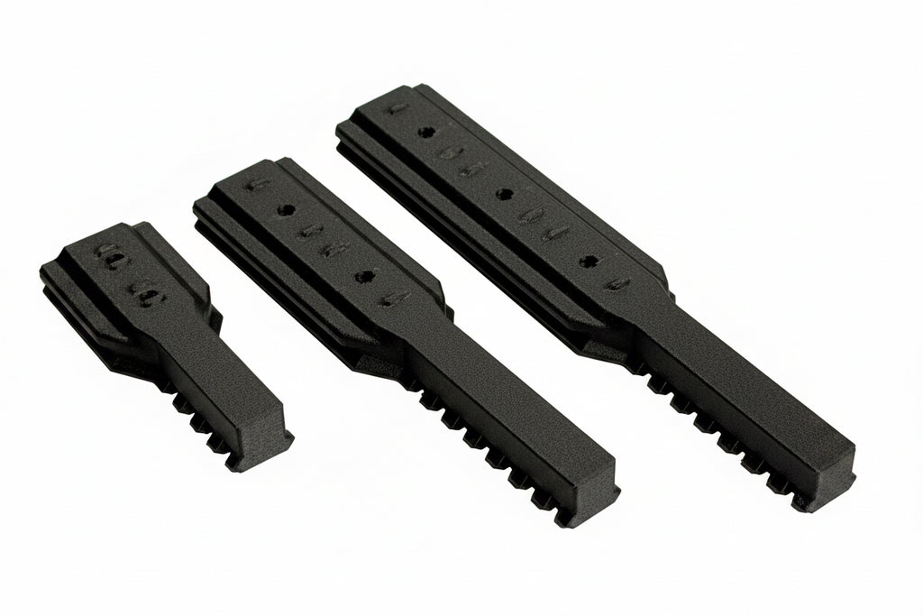 Three black plastic components on a white background