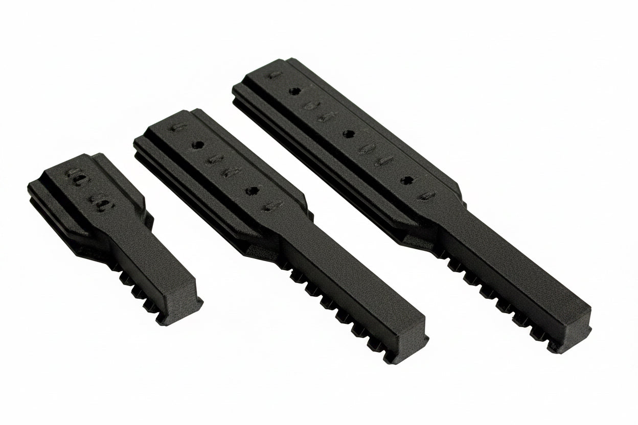 Three black plastic components on a white background