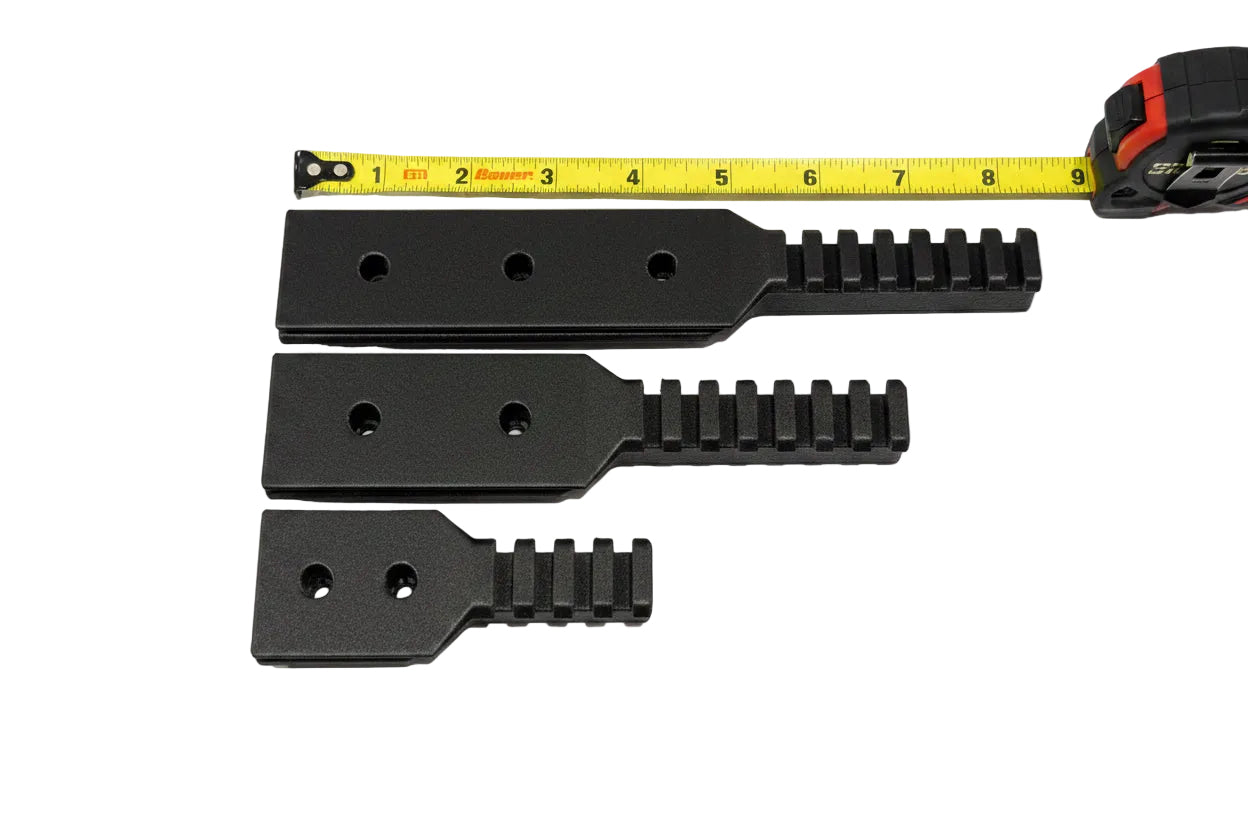 Three black rails with a tape measure for scale on a white background