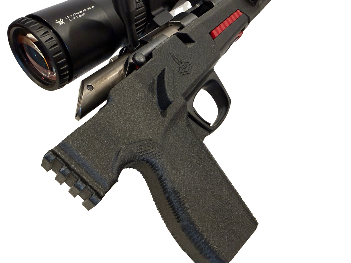 A black tactical pistol grip with a mounted black scope and a small red accent, shown on a plain white background.