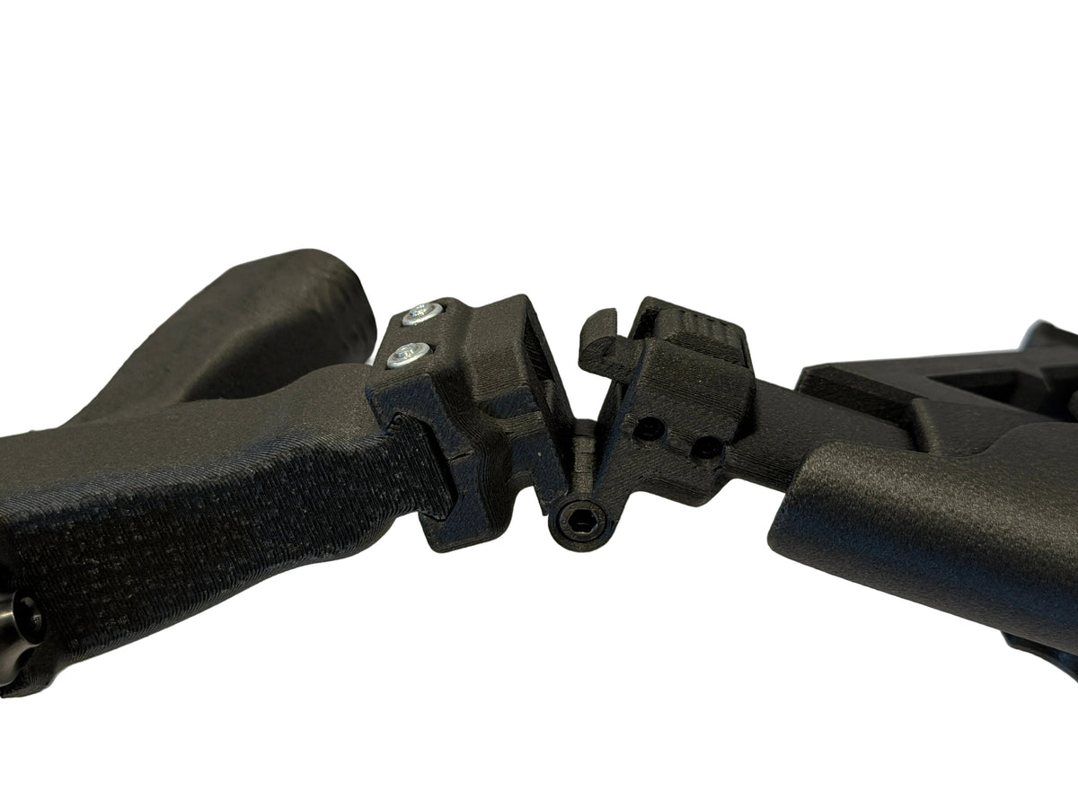 Close-up of a black tactical firearm buttstock handguard assembly showing the attachment points and textured grip.