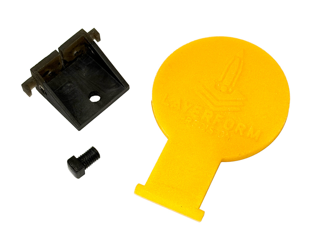 A yellow circular target, shown alongside a black plastic mounting bracket and a small black screw on a white background. The yellow cover features an embossed logo and the brand name 'layerform'.