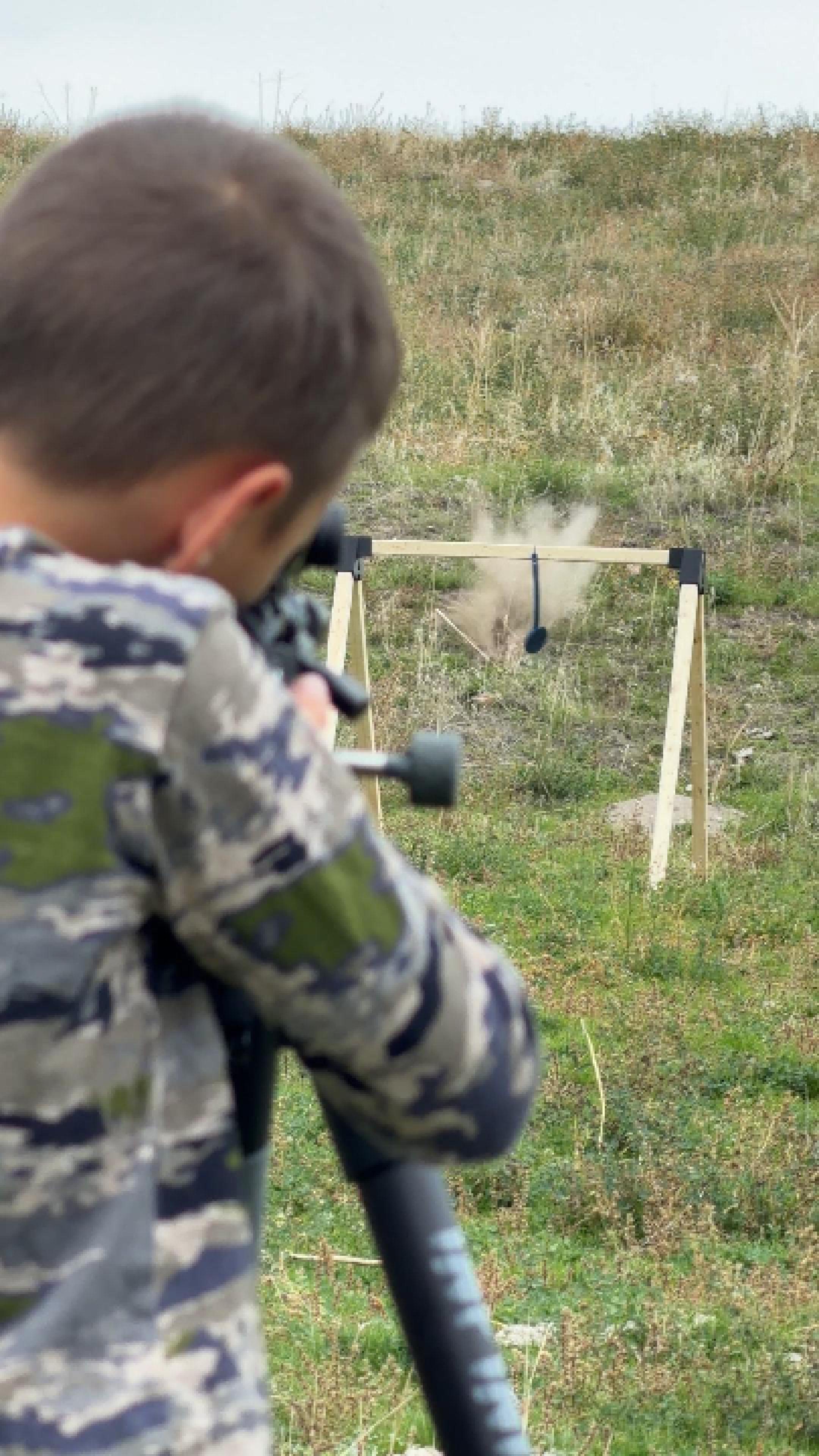 person shooting at hanging target and it swinging when it's hit