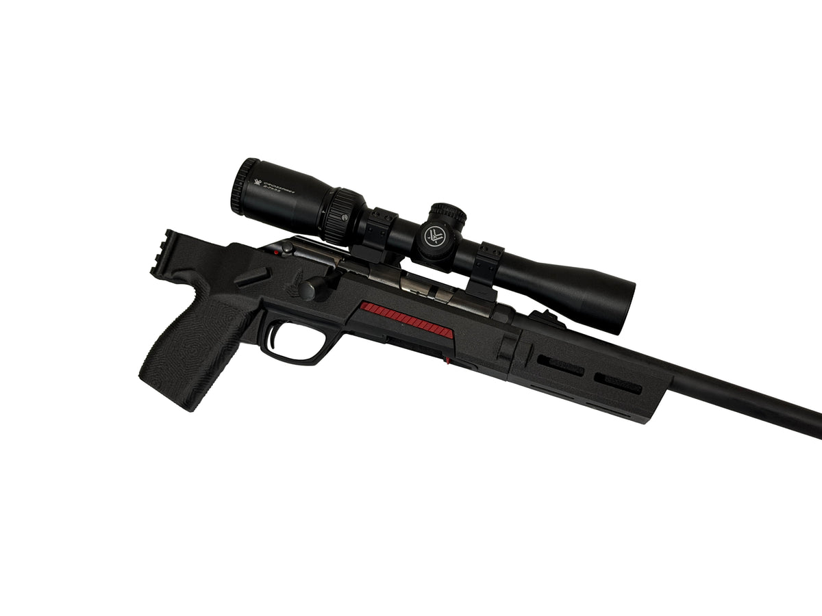 A black bolt-action rifle with an attached scope, featuring a red stripe detail on the receiver, shown against a plain white background.