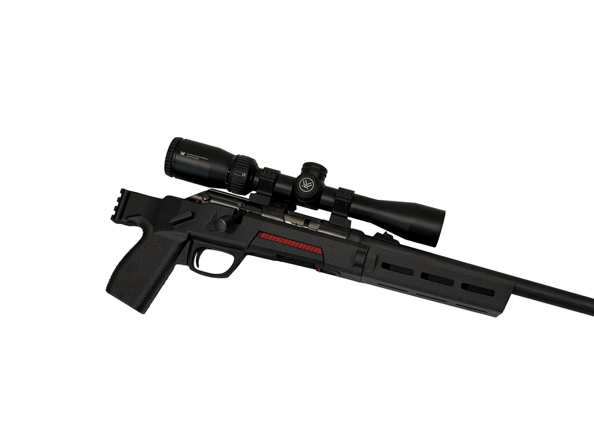 A black bolt-action rifle with an attached scope, featuring a red stripe detail on the receiver, shown against a plain white background.