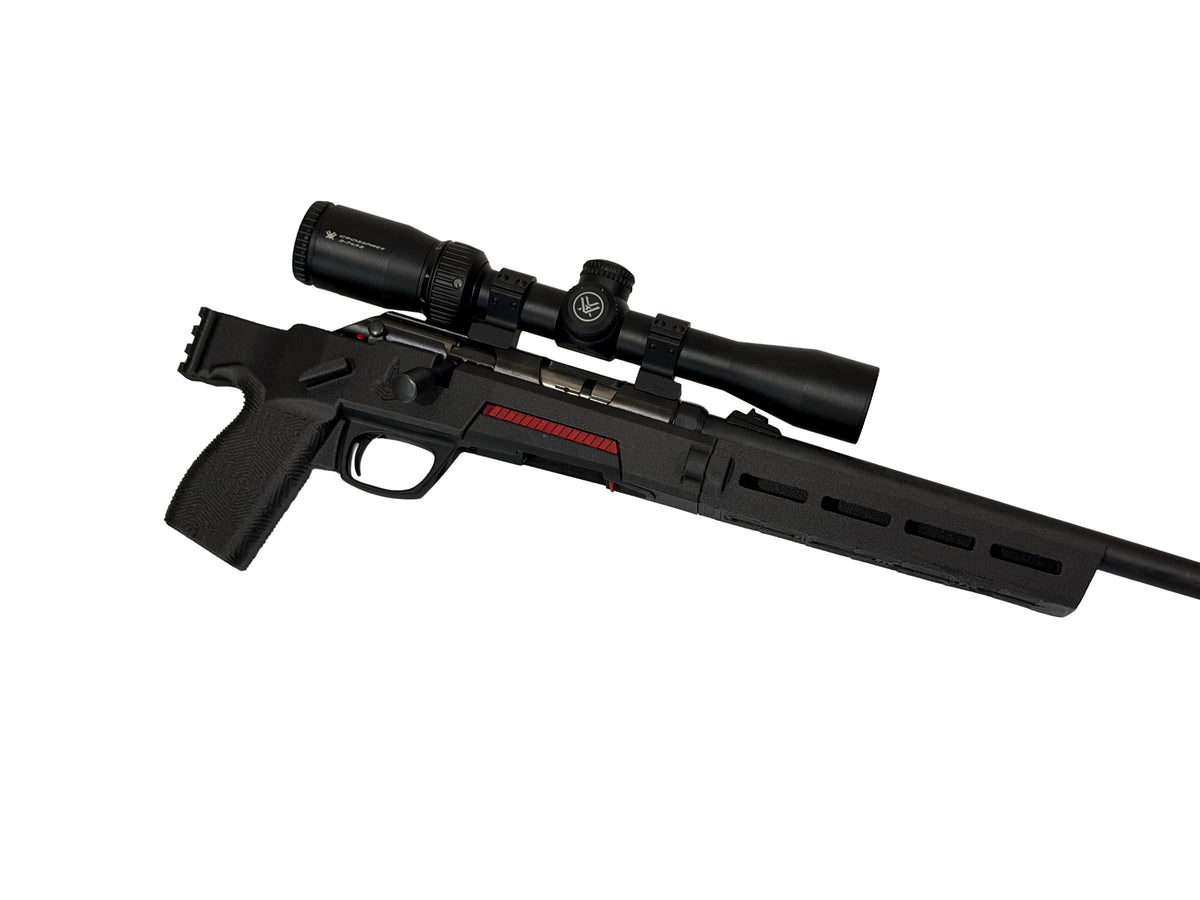 A black tactical bolt-action rifle with an attached scope, featuring a red stripe detail on the receiver, shown against a plain white background.